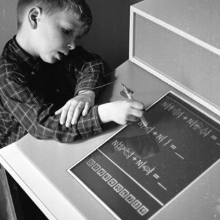 Un niño aprendiendo matemáticas en una pantalla táctil in 1965