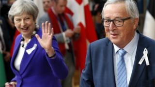 Theresa May waves at Jean-Claude Juncker
