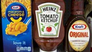 A Heinz Ketchup bottle sits between a box of Kraft macaroni and cheese and a bottle of Kraft Original Barbecue Sauce on a grocery store shelf in New York City, New York, U.S. March 25, 2015.