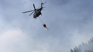Вертолет сбрасывает воду над огнем