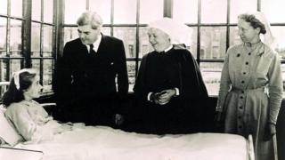 Health Secretary Aneurin Bevan talking to NHS's first patient