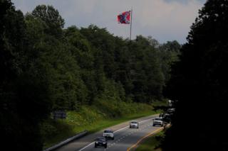 A Confederate battle flag flies over the I-64 highway, outside Charlottesville, August 1, 2018