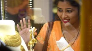 தங்கத்தை பார்க்கும் பெண்