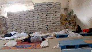 Men sleeping on the floor in a rice mill