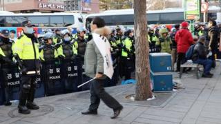 身披韓國國旗的抗議群眾,不斷地向警察挑釁