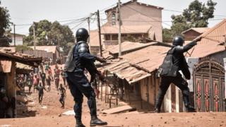 A policemen taking on protesters in neighbourhood of Conakry, Guinea - 27 February 2020