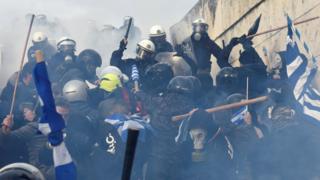 Demonstrators, including many in masks and helmets, clash with police