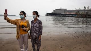 Mujeres tomándose foto con el crucero de fondo