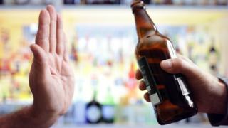 Una mano rechazando una botella