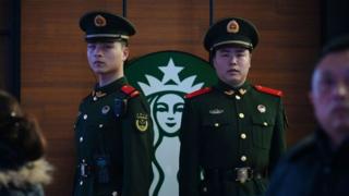 Paramilitary police officers stand guard near a Starbucks cafe in Beijing Railway Station in Beijing.