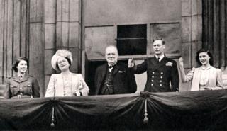 King George VI, Winston Churchill and the royal family wave to crowds from Buckingham Palace