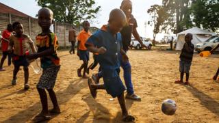 Young boys who just received a vaccine against cholera play football in Harare, Zimbabwe, on 5 October 2018