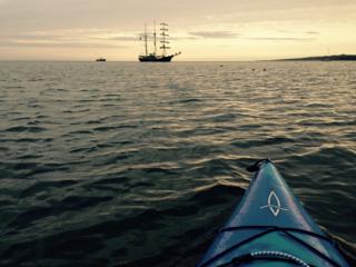 Kayak and tall ship