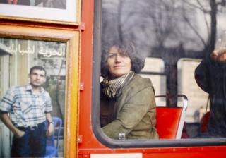 A Syrian refugee looks out of a bus a window