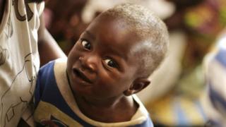 Мать держит своего улыбающегося ребенка во время посещения Первой леди Организации Объединенных Наций (ООН) Пан Сантэка (не изображена) в детской больнице принцессы Марии Луизы в Аккре 20 апреля 2008 года.