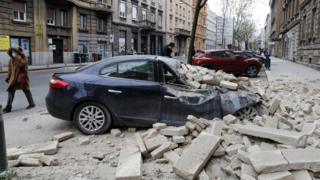 A person walks past rubbles lying on a street after a 5.3-magnitude earthquake that hit near Zagreb, Croatia, 22 March 2020