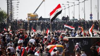 Iraqi security forces stand in front of demonstrators during a protest over corruption, lack of jobs, and poor services, in Baghdad, Iraq October 25, 2019