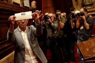 Un parlamentario enseña su voto con "no" antes de meterlo en la urna.