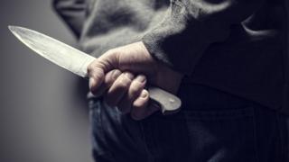 A man holds a sharp knife