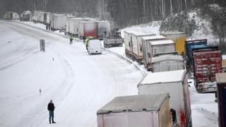 Trucks wait in a queue as vehicles are still stuck along the European route E22, in Linderod, southern Sweden, 04 January 2024
