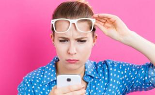 Mujer mirando al celular sospechosa