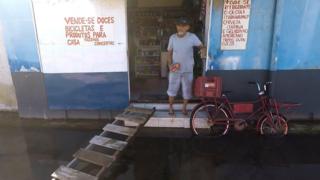 Venda em rua alagada com bicicleta estacionada na porta