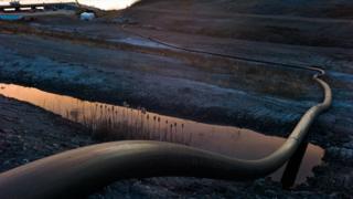 A water intake pipe for oil sands operations leads downhill to the Athabasca River on April 28th, 2015 north of Fort McMurray, Canada. Fort McMurray is currently coping with an economic downturn as a result of low oil prices and most of the layoffs have been impacting the transient workforce. Canada's oil and gas industry is expected to lose 37% of its revenues in 2015.