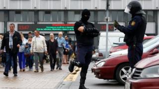 Law enforcement officers stand guard as people, including employees of Minsk Tractor Works, gather near the plant to protest against presidential election results and to demand re-election in Minsk, Belarus August 19, 2020.