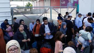 Palestinians with dual citizenship wait at the Rafah border crossing between Israel and Gaza