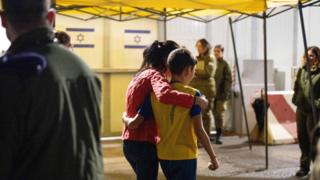 Eitan Yahalomi, 12, walks with his mother at the Kerem Shalom border crossing
