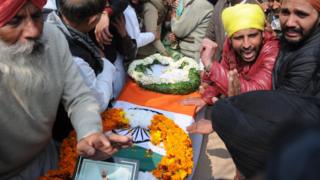 Relatives of Central Reserve Police Force soldier Sukhjinder Singh mourn near his coffin before his cremation ceremony at village Gandiwind in Tarn Taran district