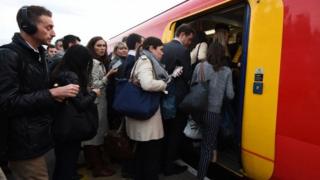 Пассажиры садятся в переполненный поезд