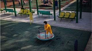 Ученица начальной школы играет в общественном парке в Гонконге