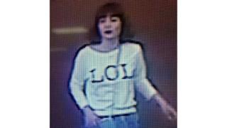 Grainy image shows a woman with brown hair wearing a T-shirt with the letters "LOL" emblazoned on it