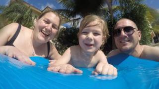 Kati Charles com marido e filho na piscina
