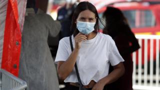 A woman wearing a protective face mask leaves after her swab samples are taken by volunteering firefighters at a test station for Covid-19 coronavirus in Marseille, France,