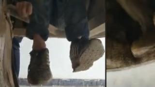 Two boys hiding under a bus in China