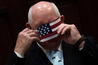 US Secretary of Agriculture Sonny Perdue puts on a face mask