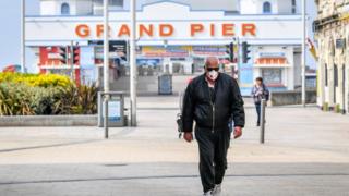 Man walks in front of Grand Pier at Weston-super-Mare