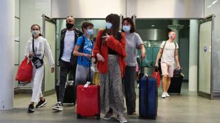 Tourists in face masks with their luggage at the Eurostar terminal at St Pancras Station in London.