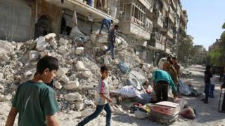 People remove belongings after an air strike in the rebel-held Qaterji district of Aleppo, Syria (17 October 2016)