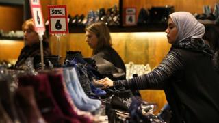Customers look at discounted shoes