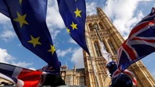 Flags blowing in the wind outside the Houses of Parliament in London