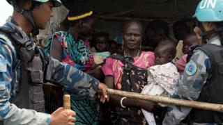 United Nations peacekeepers control South Sudanese women and children before the distribution of emergency food supplies at the United Nations protection of civilians (POC) site - July 2016