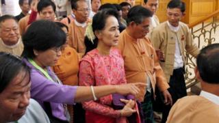 Myanmar's pro-democracy leader Aung San Suu Kyi, center, arrives to participate in the inaugural session of Myanmar"s lower house parliament Monday, Feb. 1, 2016 in Naypyitaw, Myanmar.
