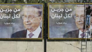 رجل يقوم بوضع ملصق إعلاني لميشال عون الذي اختير رئيسا للبنان
