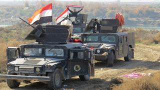 Iraqi pro-government forces display national flags in the al-Aramil area, south of Ramadi (22 December 2015)