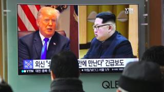 Люди смотрят телерепортаж с фотографиями президента США Дональда Трампа (слева) и лидера Северной Кореи Ким Чен Уна на железнодорожной станции в Сеуле 9 марта 2018 года.