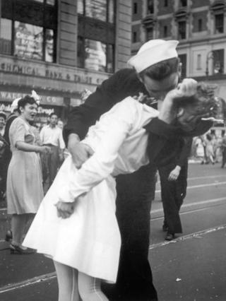 Sembolik fotoğrafta denizci hemşireyi belinden kavrayıp öperken görülüyor.