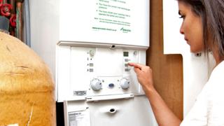 Woman using a gas boiler